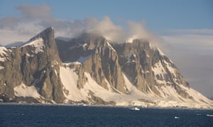 Unnamed peaks on the west coast of the Antarctic peninsula tower over the harsh Antarctic coast.