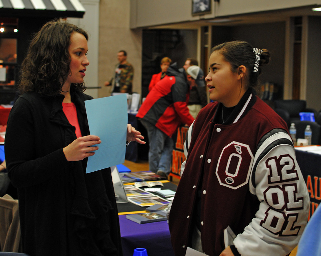 College Counselor speaking with high school student at college fair