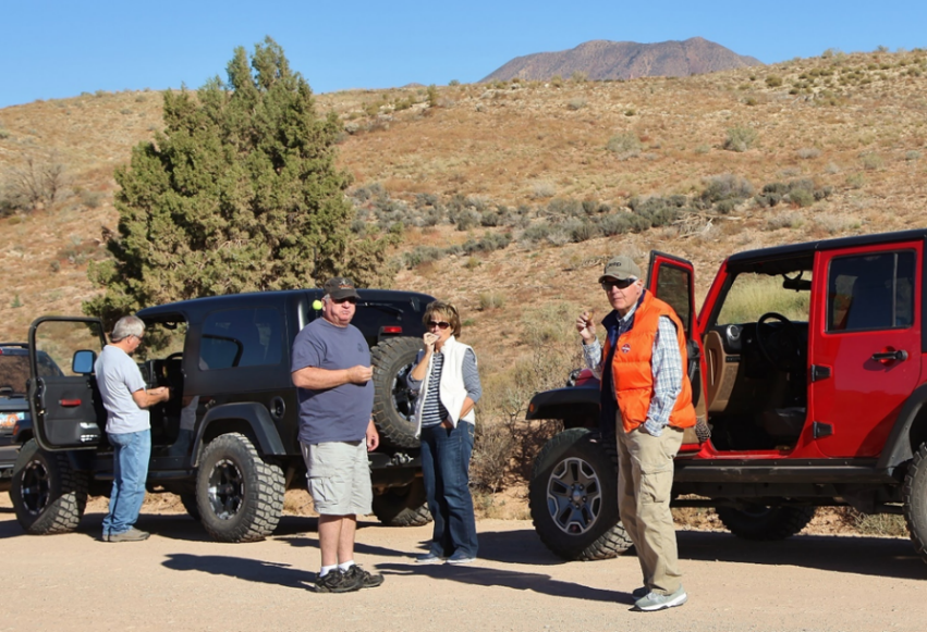 A group of people standing next to a red truck</p>
<p>Description automatically generated with medium confidence