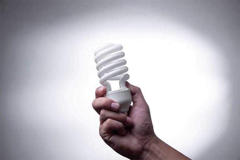 A hand holding a light bulb

Description automatically generated