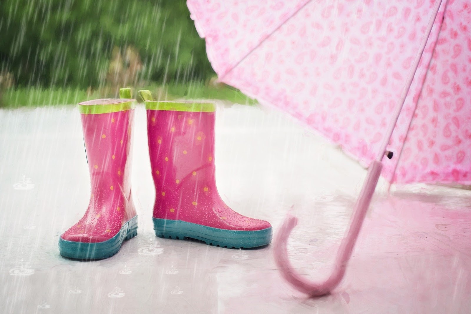 Um par de botas embaixo de um guarda-chuva.
