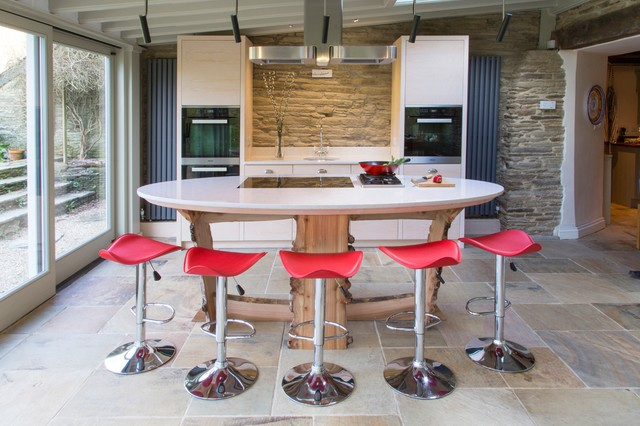 large basement kitchen with unique island design, red barstools, tile floors and white countertop