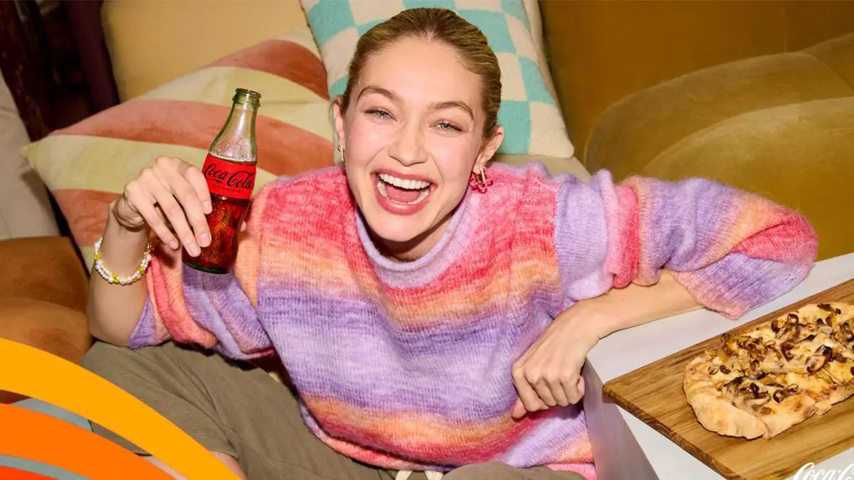 Gigi Hadid smiles with a Coke in hand for this celebrity endorsement.