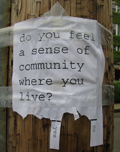 sign taped to telephone pole reads 'Do you feel a sense of community where you live?' and has rip-off tabs at the bottom reading 'yes' and 'no.'