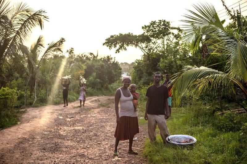 A group of people walking on a dirt path with palm trees

Description automatically generated with medium confidence