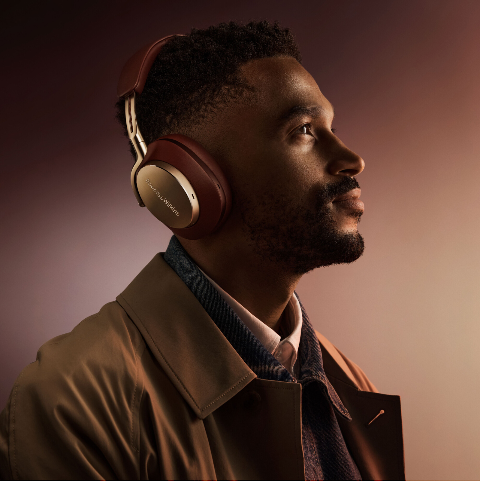 A man wearing Bowers & Wilkins Px8 Wireless Headphones in Royal Burgundy finish.