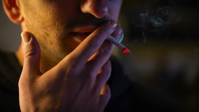 Gelegenheitsrauchen - junger Mann zieht an einer Zigarette