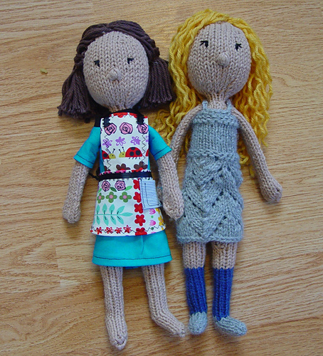 tall knit dolls with dresses on wooden background