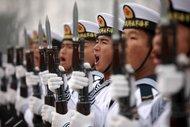 港口城市青岛，某军事基地的阅兵场上，中国人民解放军海军新兵在喊口号。