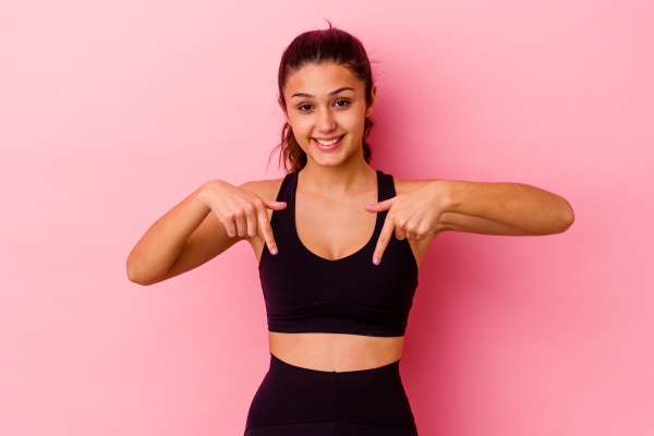 young-sport-indian-woman-isolated-pink-points-down-with-fingers-positive-feeling