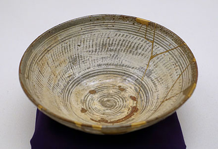 A ceramic bowl, broken and repaired with gold.