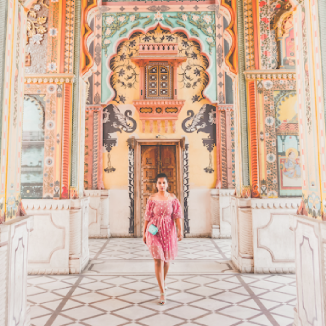 A girl in a pink dress walking in a colourful corridor