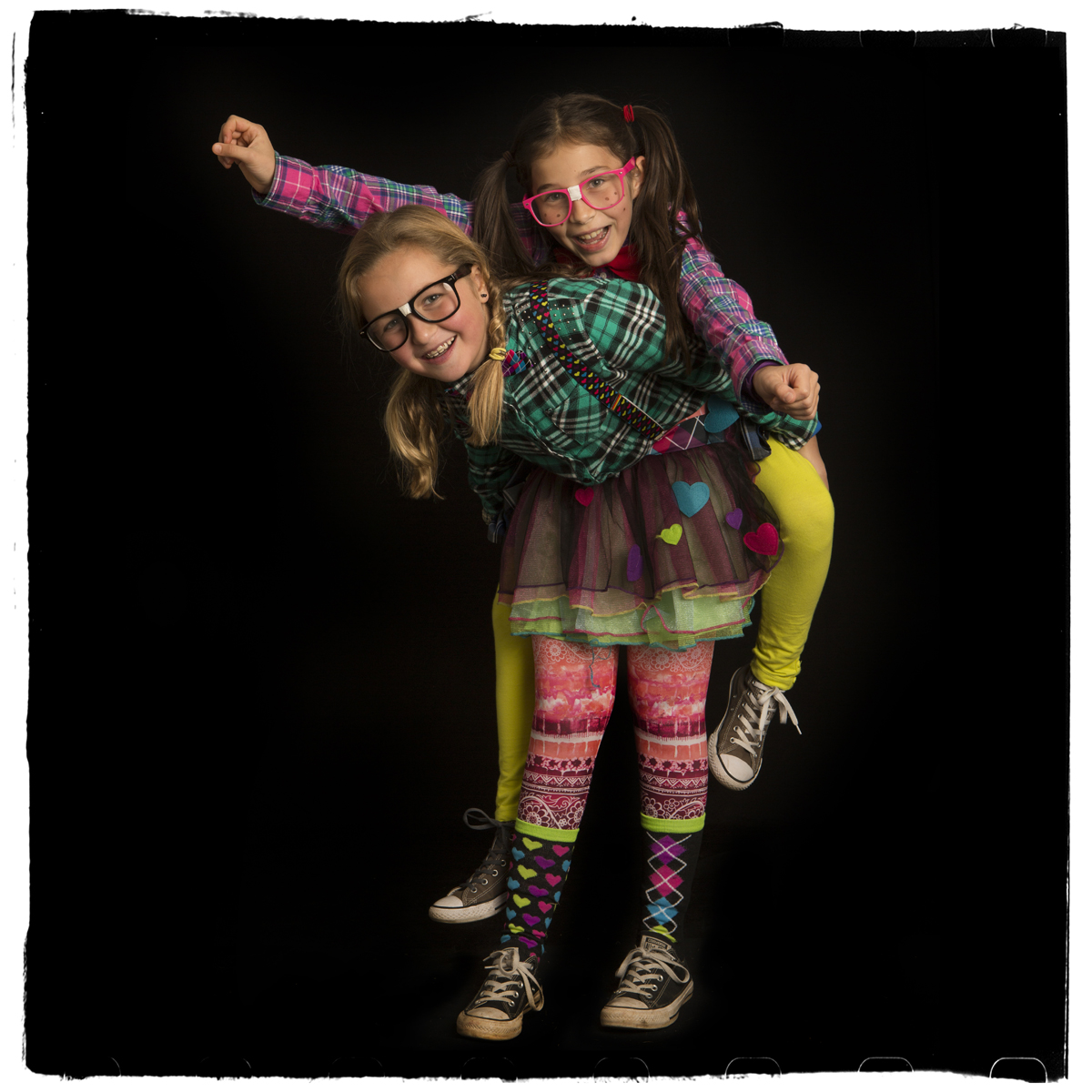 Two girls dressed up in colorful Halloween costumes.