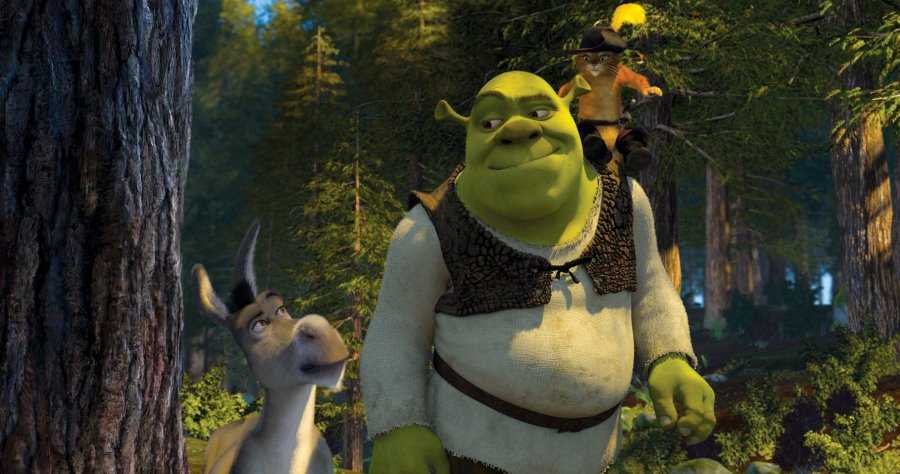A screen still from Shrek 2, featuring Shrek, Donkey, and Puss in Boots, as they walk through the forest together. Puss is sitting on Shrek's shoulder.