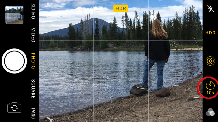 Screenshot of using the iphones self timer to take a photo of a girl standing by a lake