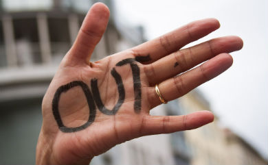 Woman with 'out' written on her palm