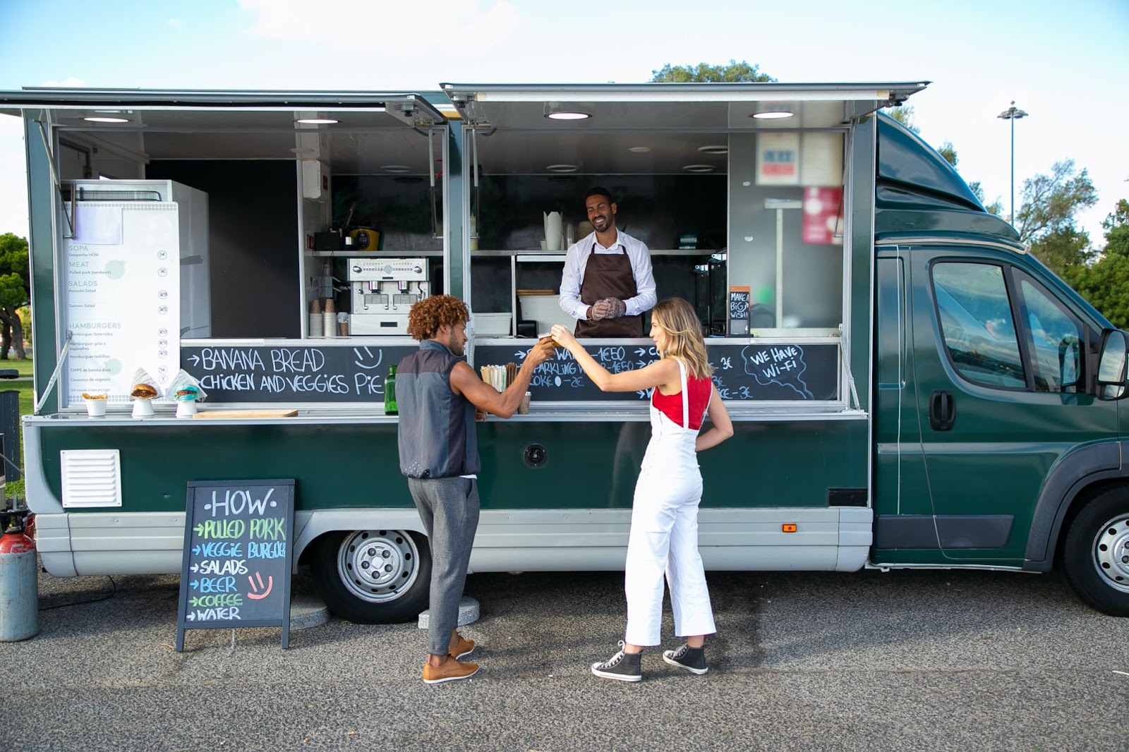 An image of a man and a woman standing at a food truck depicting that food truck is one of the innovative food business ideas