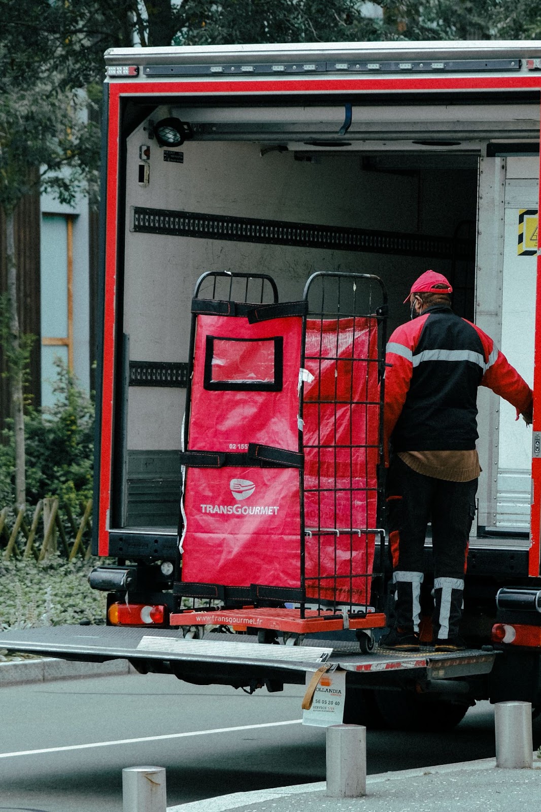 A man moving a parcel on a liftgate from the back of his semi truck