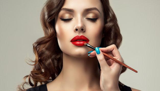 Makeup artist applies red lipstick . Beautiful woman face. Hand of make-up  master, painting lips of young beautiful model. Makeup in progress Stock  Photo | Adobe Stock