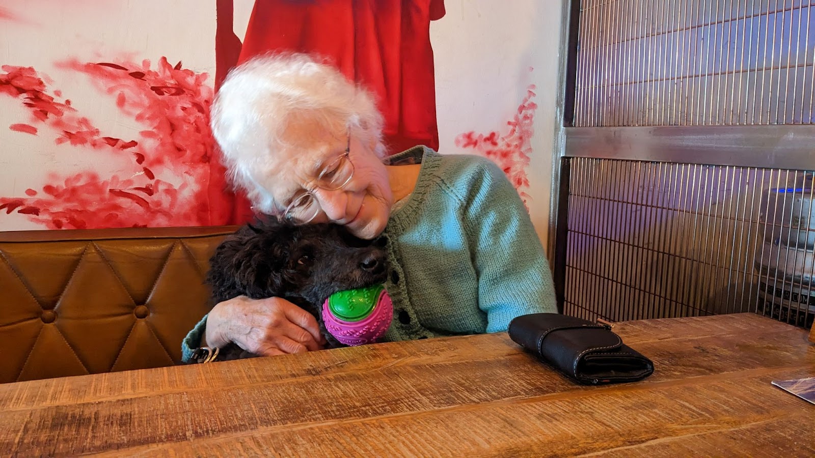 Photo of Iris having a cuddle with a black poodle named Dora