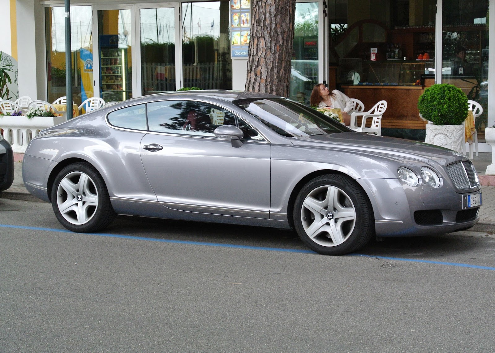 A silver 2004 Bentley Continental GT car on a city street. 