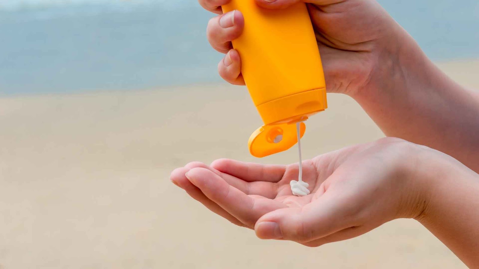 sunscreen being squeezed into a hand