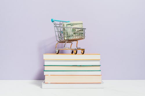 Free Shopping Cart on Top of Books Stock Photo