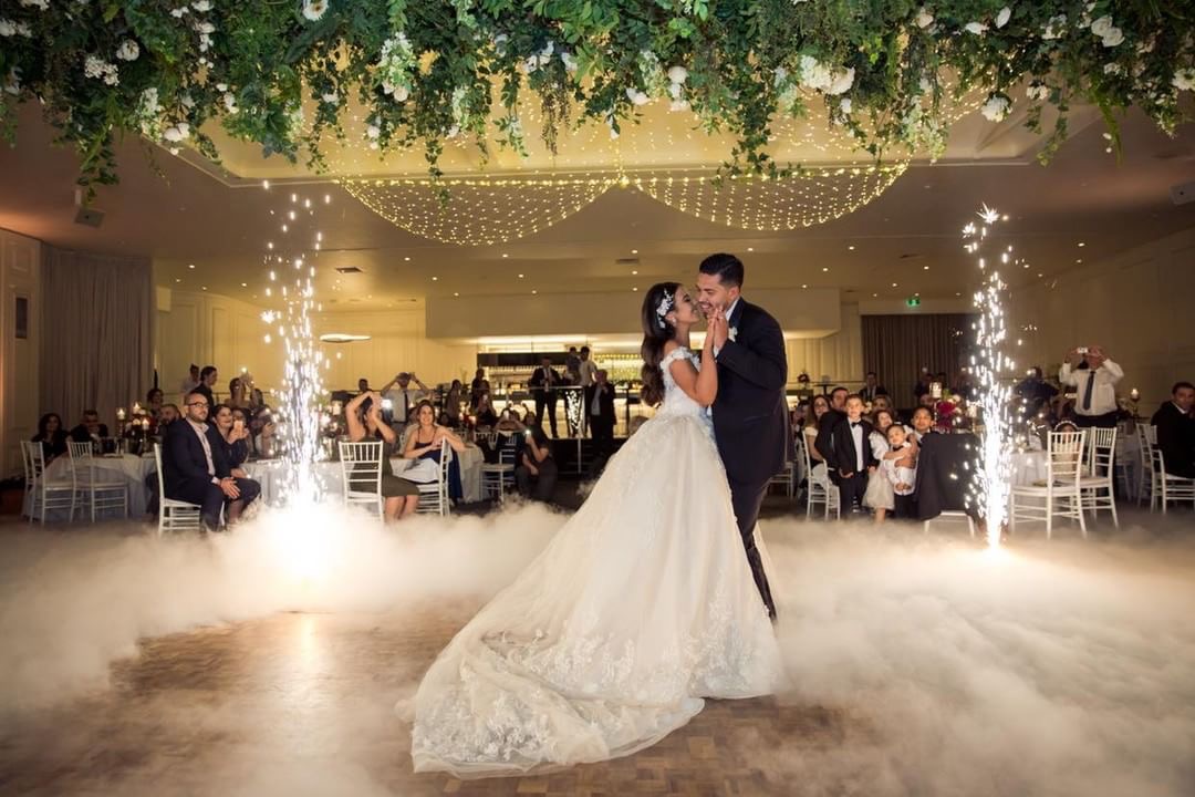 A beautiful Leonda couple dancing under a Greenery inspired chandelier