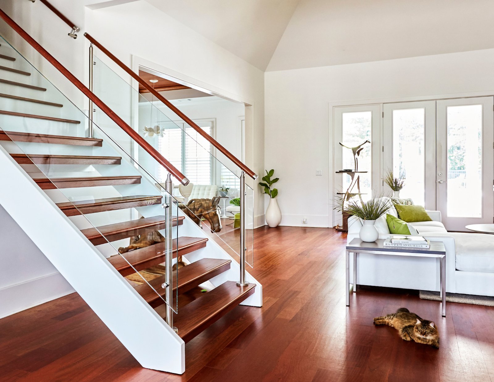 Modern straight staircase with wood and metal rails and a horizontal glass wall