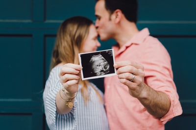 couple holding a picture of their baby inside the tummy