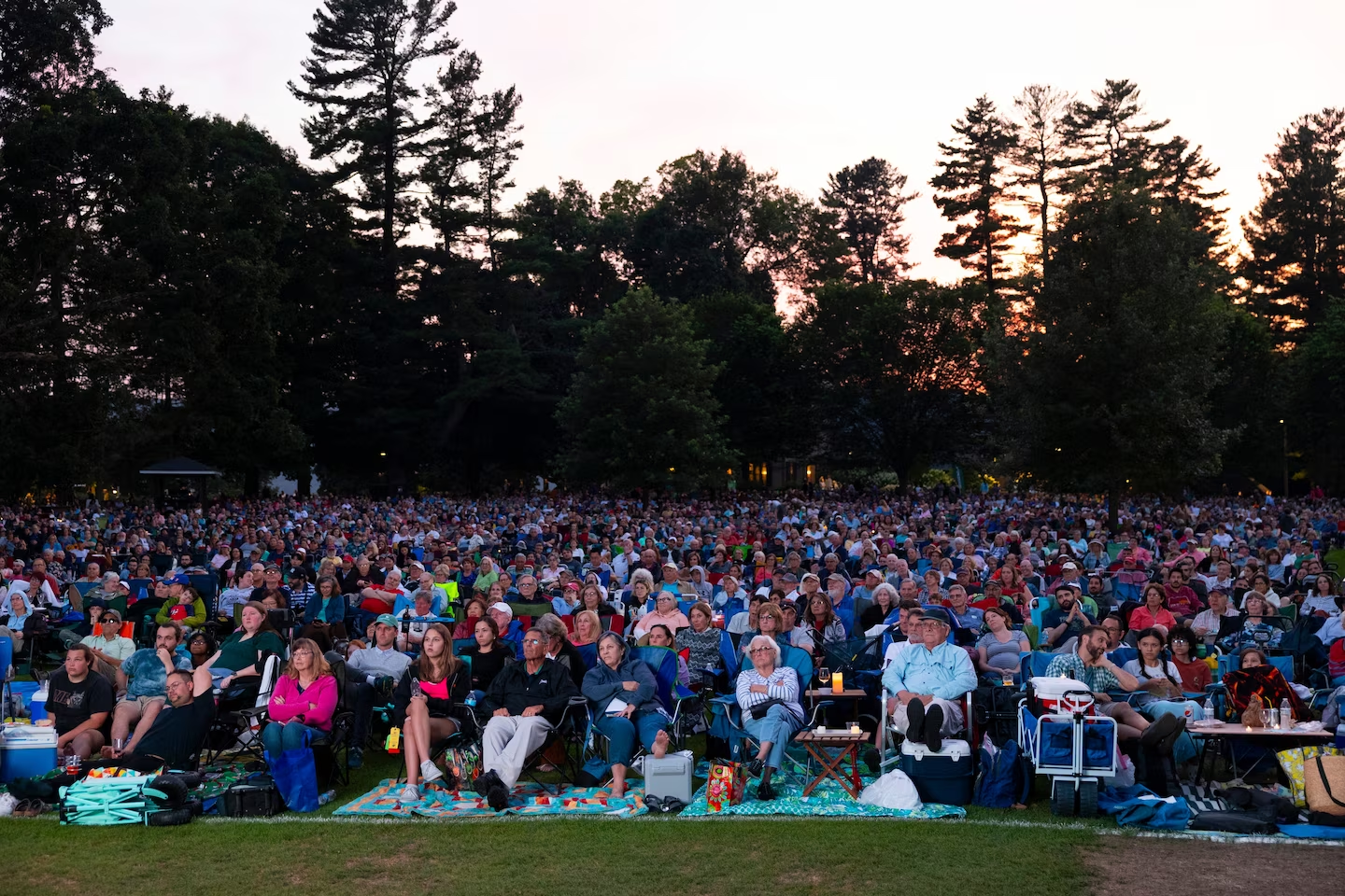 A crowd on blankets and folding chairs assembles on the lawn of Tanglewood.