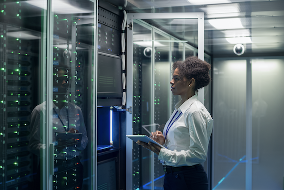 Wearable technology in healthcare: Female worker holding a tablet while looking at data machine