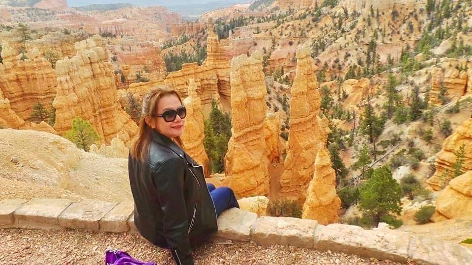 Image of Candy sitting on a ledge overlooking the hoodoos of Bryce Canyon National Park 