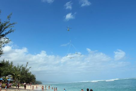 Hélicoptère tractant un appareil de géophysique au dessus d\'une plage de l\'île de la Réunion.  Crédit : SkyTEM