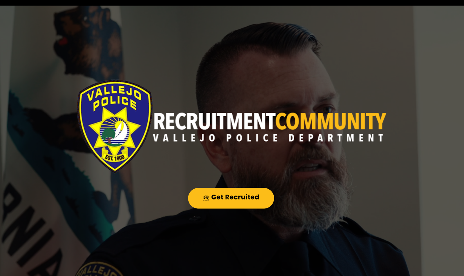 A screenshot featuring the Vallejo police logo with the words "Recruitment Community: Vallejo Police Department" with an image behind it of a white man with a long grey beard in a blue police uniform. 