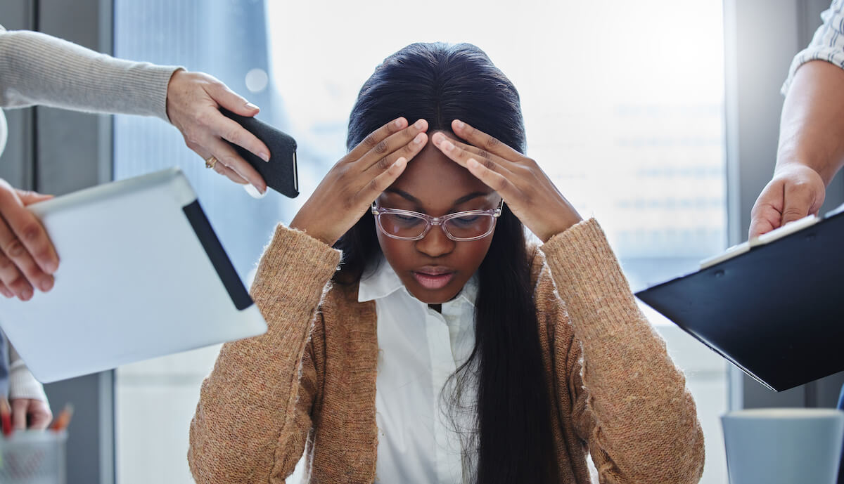 FMLA for mental health: stressed employee holding her forehead