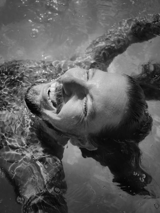 Grayscale Photo of Man in Water