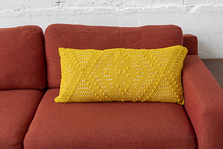 long, rectangular crochet pillow in a mustard color