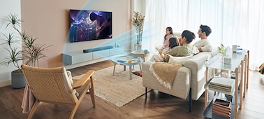 A family watching TV with blue sound waves emanating from the soundbar