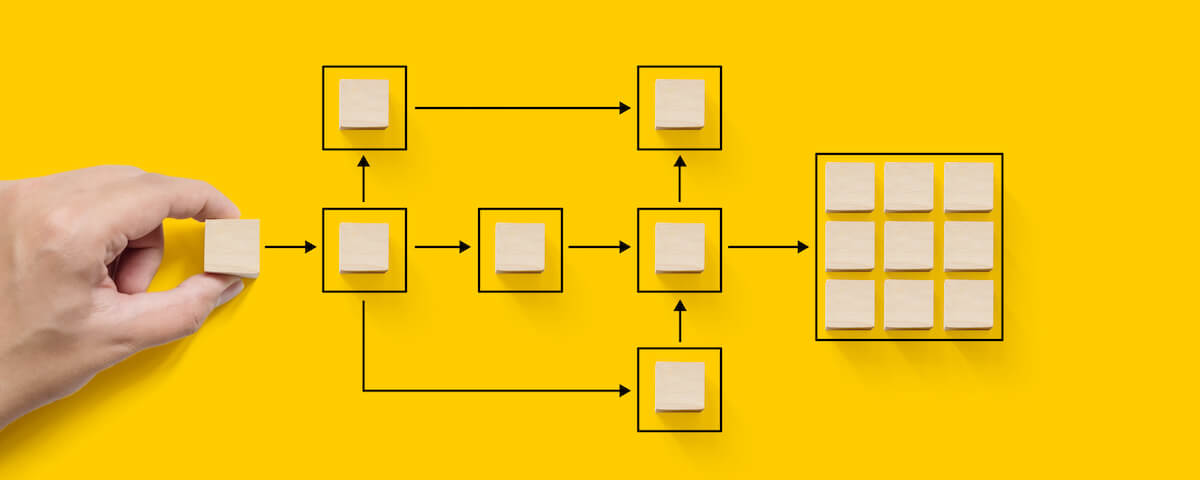 Person adding squares to flowchart of boxes