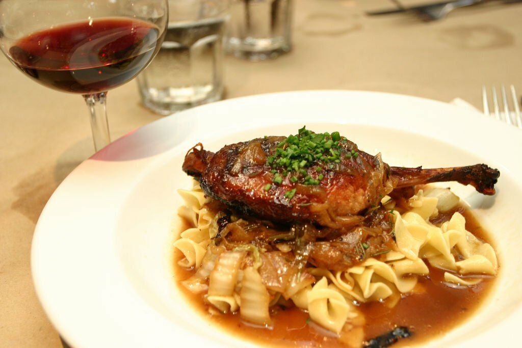 Duck Confit with red wine on the table.