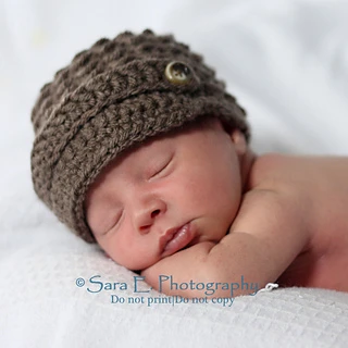 baby wearing a brown newsboy hat