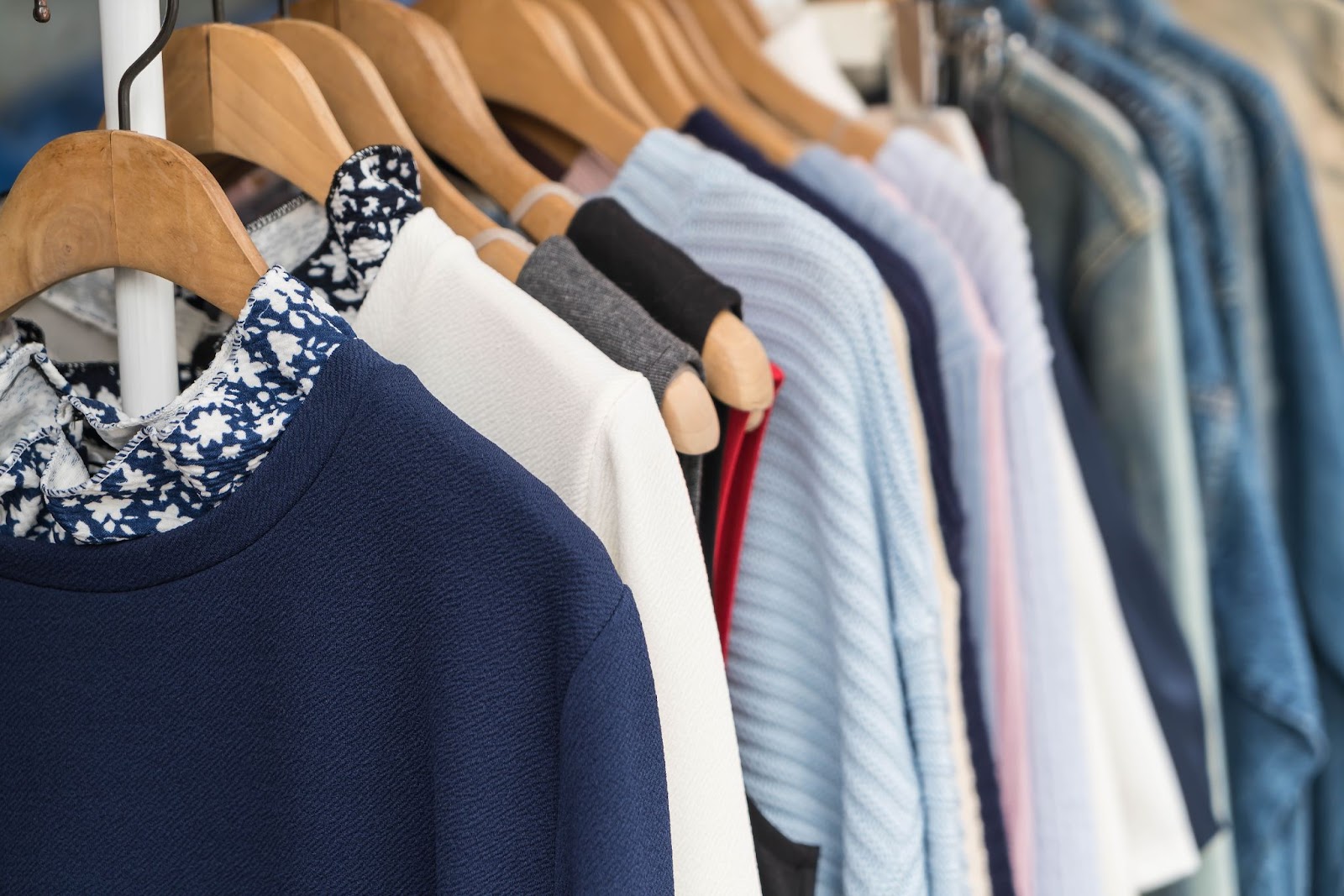 arara de roupas com diversos tipos de camiseta e cores 