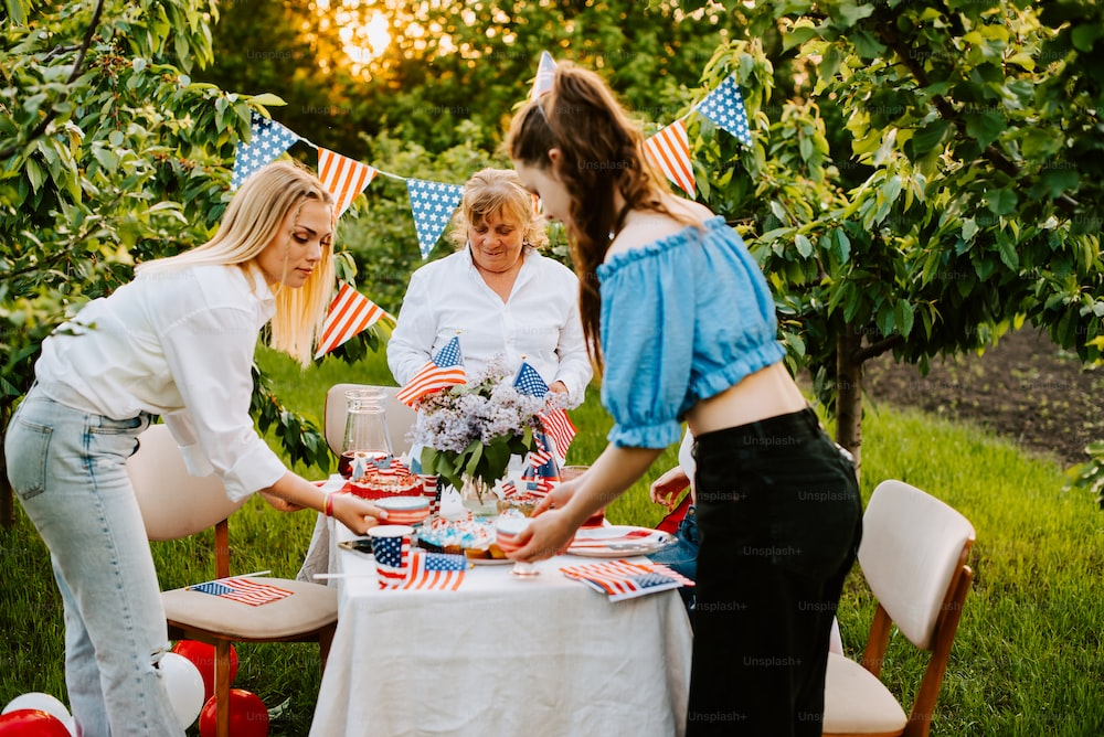  Women setting the table in the backyard ahead of the 4th of July celebration with friends 