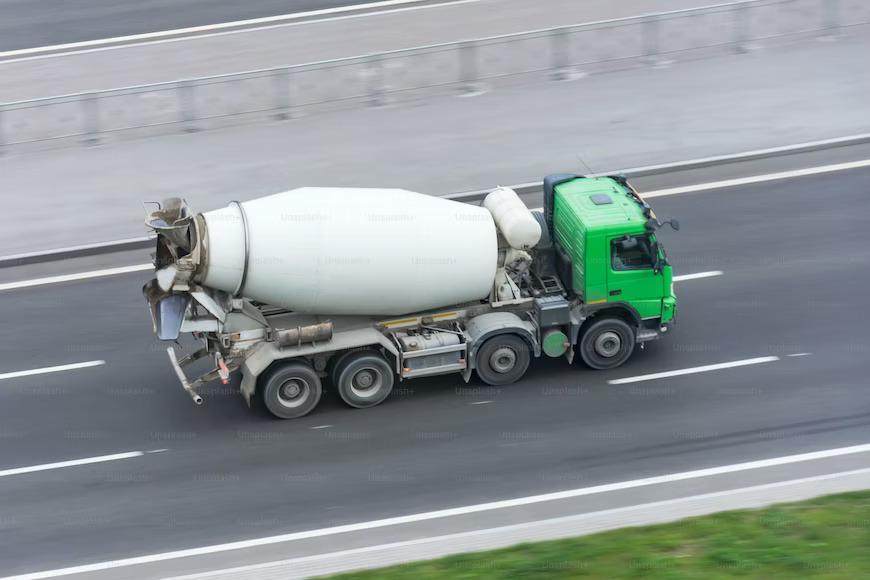 A cement truck in motion on a busy road
