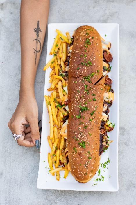 A long sandwich and french fries on a white plate

Description automatically generated with low confidence
