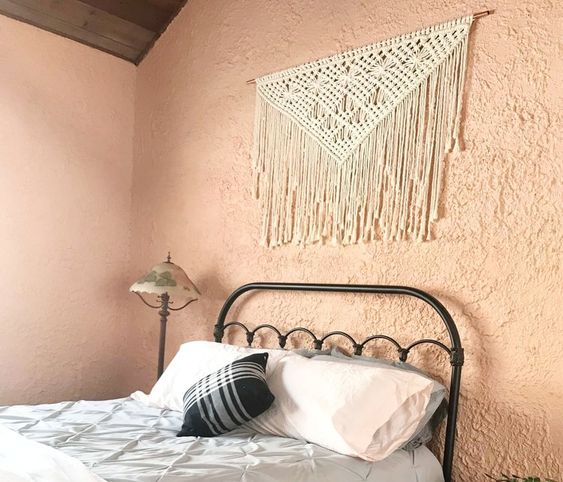 You can use a macrame wall hanging to frame a bed without a headboard