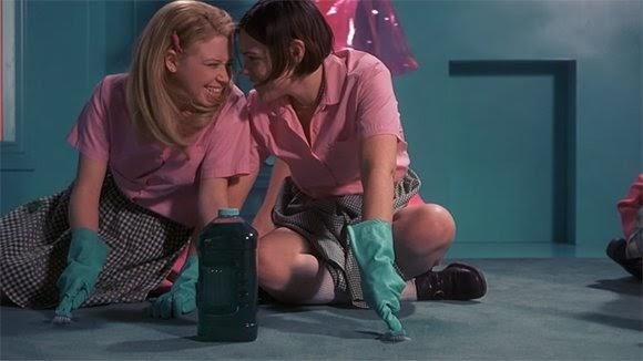 A screen still of Natasha Lyonne and Clea DuVall in But I'm a Cheerleader (2000), scrubbing the floor and flirting.