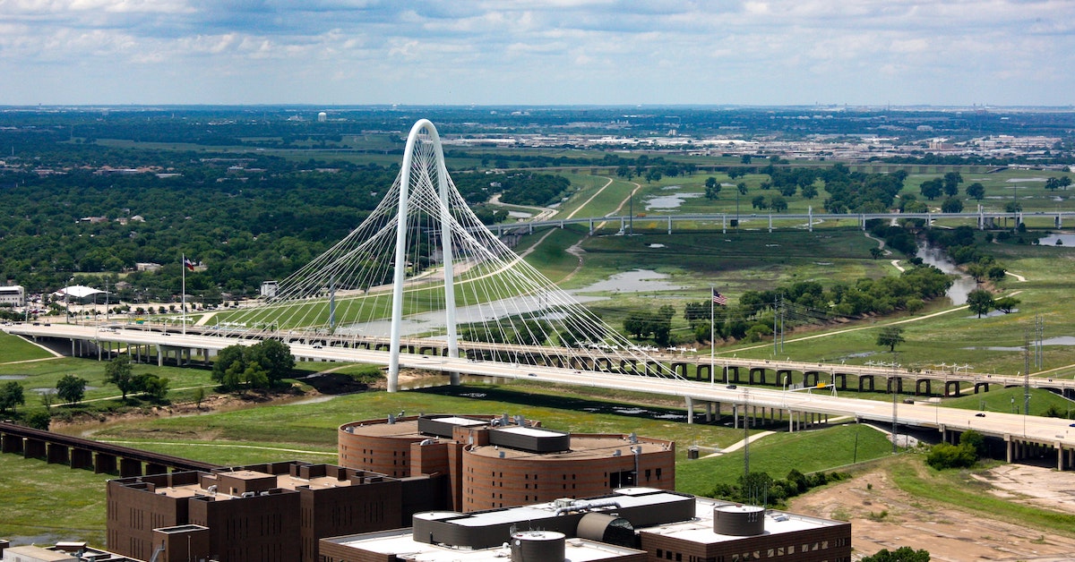Aerial view of the Margaret Hunt Hill Bridge in Dallas Texas stretching over the land's greenery.