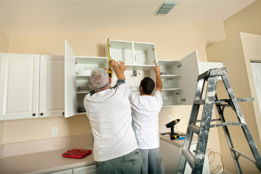 contractors installing kitchen cabinets during a home remodel custom built michigan